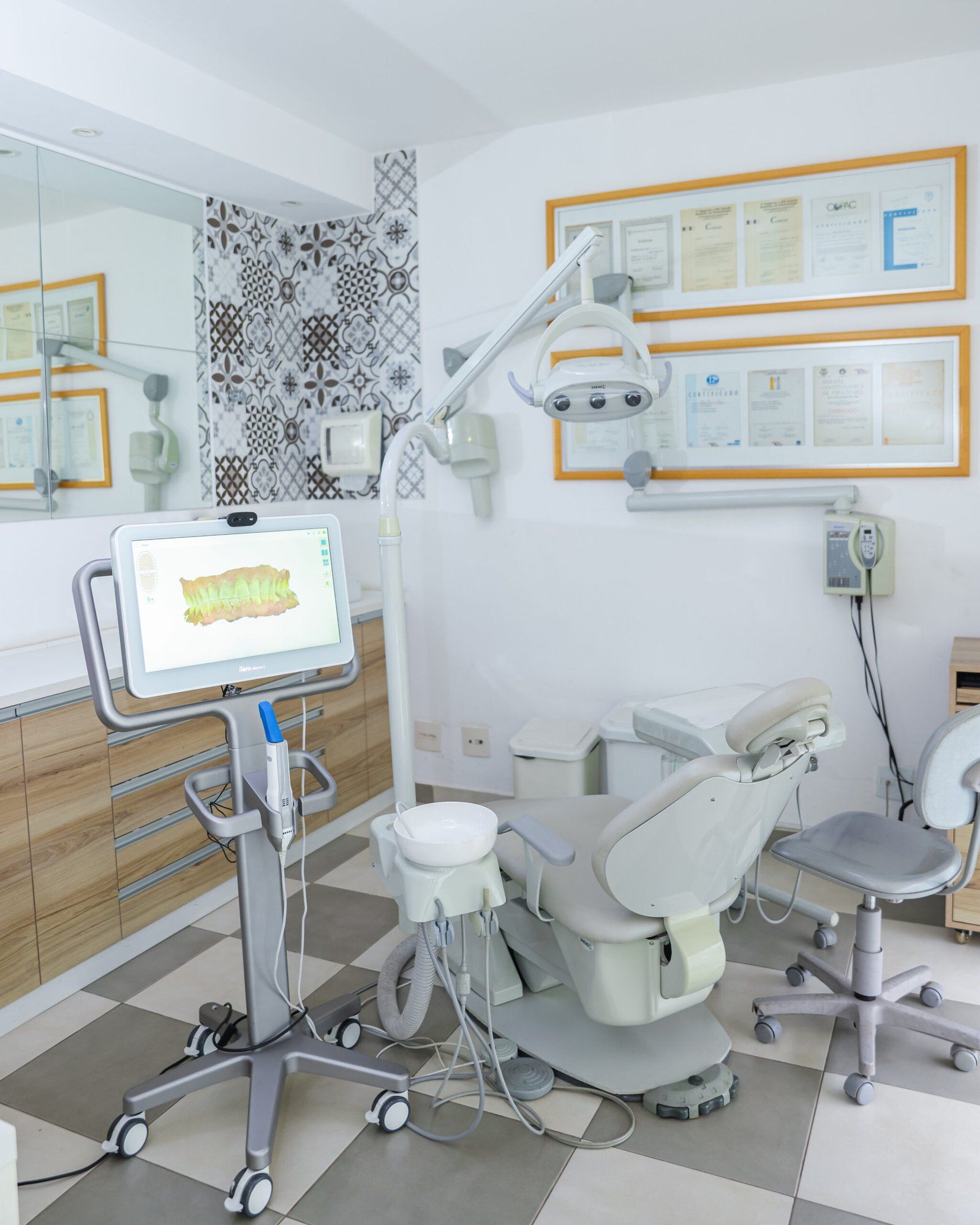 Consultório com cadeira odontológica e o scanner intraoral iTero mostrando os dentes em 3D